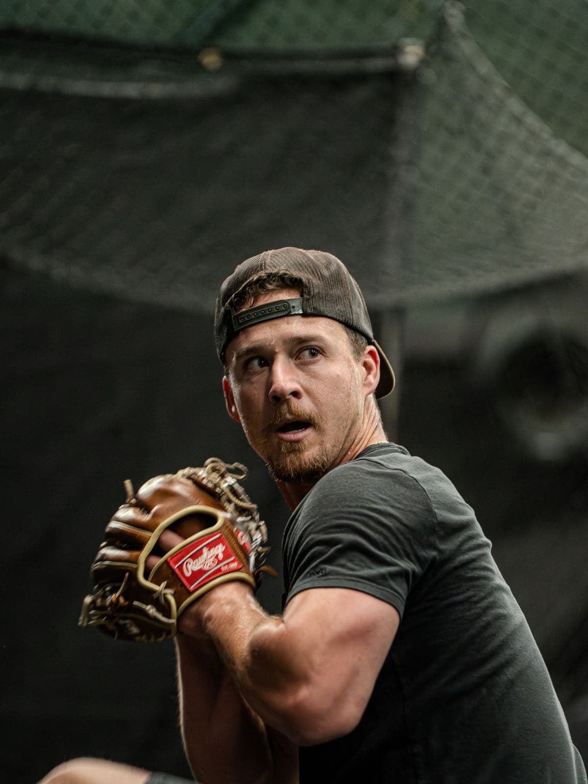 A pitcher set with the ball hidden in his glove, looking in for the sign