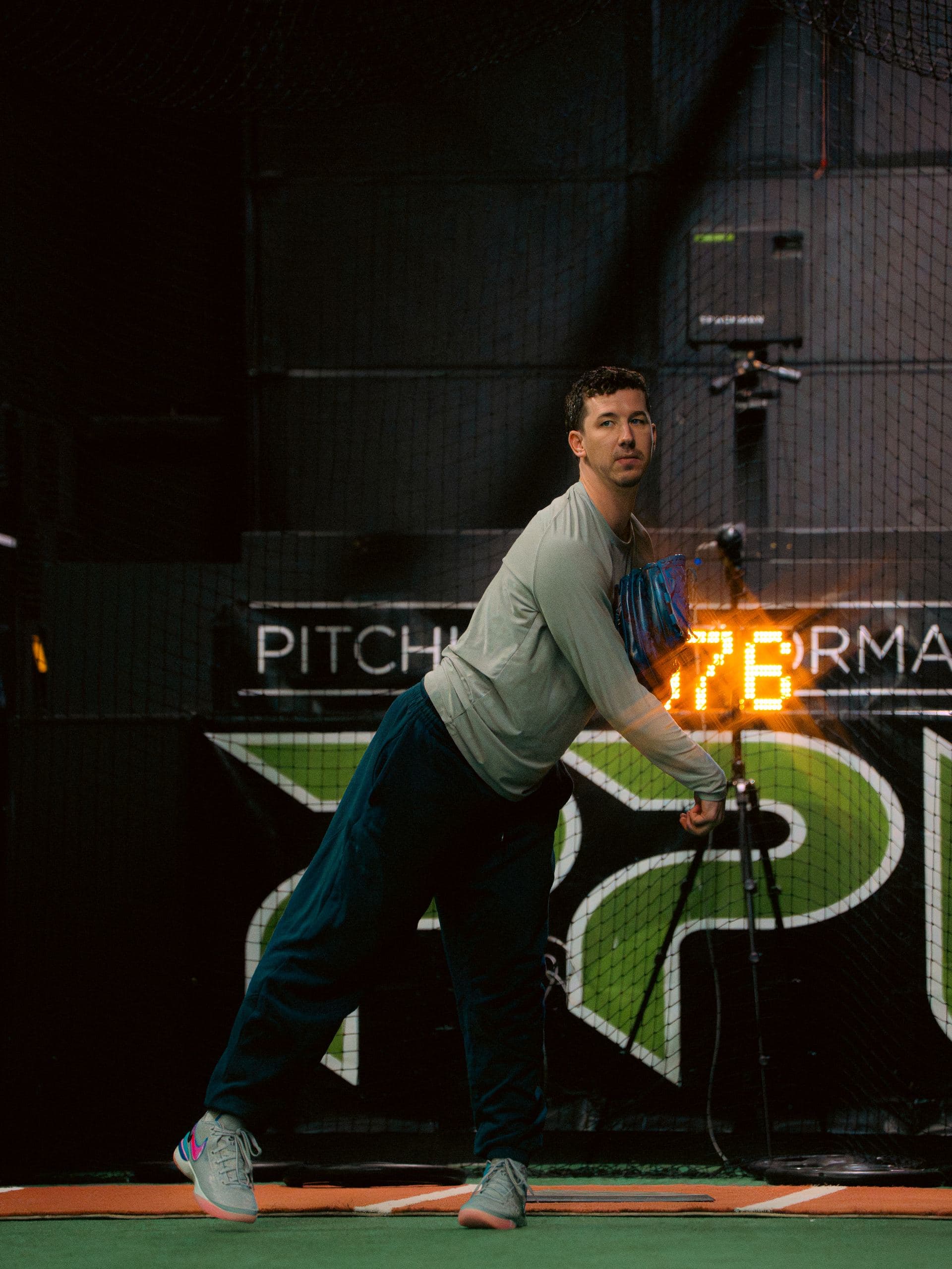 A PPL pitcher releasing in front of the branded wall and velo readout
